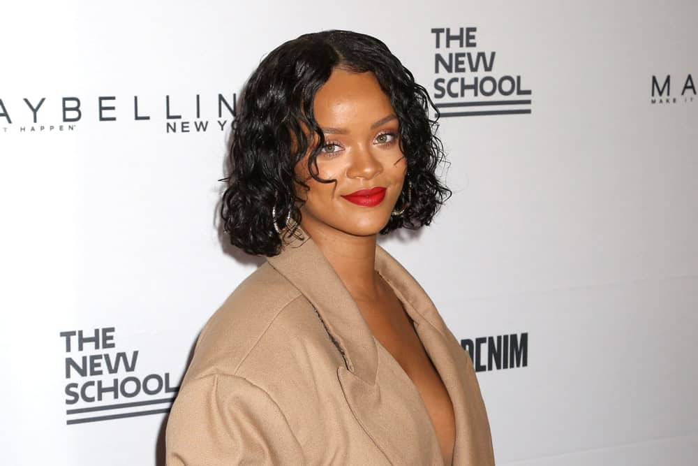 Rihanna attended the 69th annual Parsons Benefit at Chelsea Piers on May 22, 2017, in New York. She wore a fashionable brown dress that looks like a trench coat and paired this with her short and curly bob hairstyle.