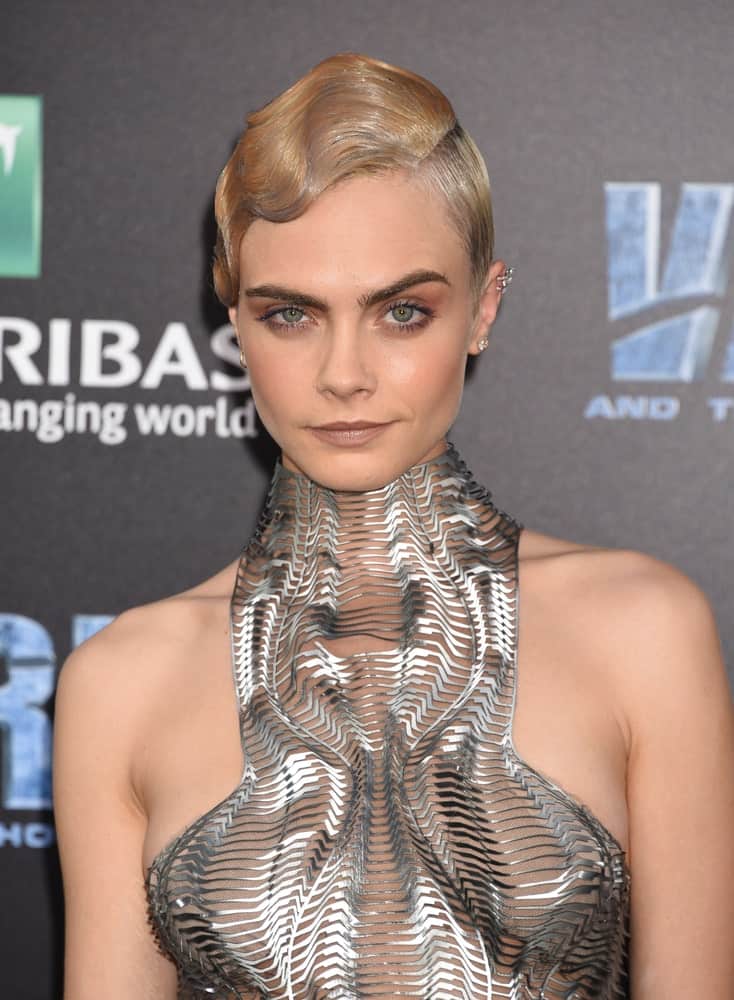 Cara Delevingne attended the "Valerian And The City Of A Thousand Planets" World Premiere on July 17, 2017 in Hollywood, CA. She was quite fashionable in her metallic futuristic dress that she paired with a slick side-parted bun hairstyle with a sandy blond tone.