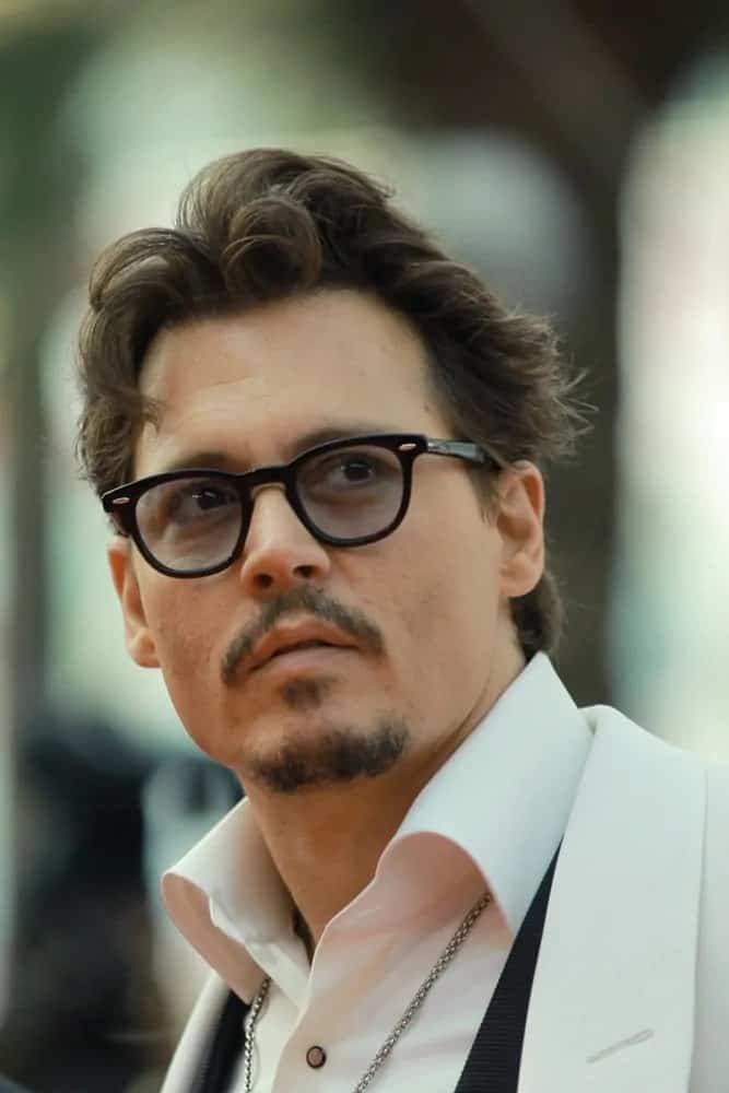 Johnny Depp looked classy with his brushed up tousled and wavy hairstyle and stylish mustache at the "Pirates of the Caribbean: On Stranger Tides" Premiere at Palais des Festivals on May 14, 2011 in Cannes, France.