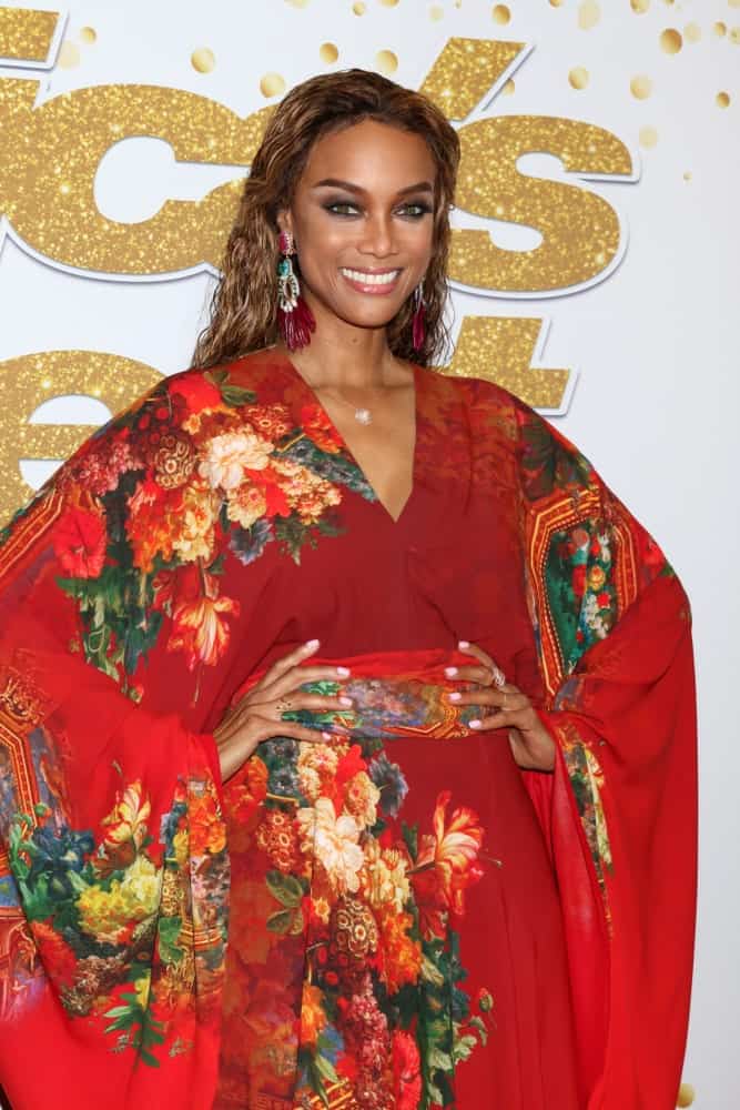 Tyra Banks' colorful floral kimono is a nice pairing for her long and loose tousled hair with highlights at the "America's Got Talent" Live Show Red Carpet at the Dolby Theater on September 11, 2018 in Los Angeles, CA.