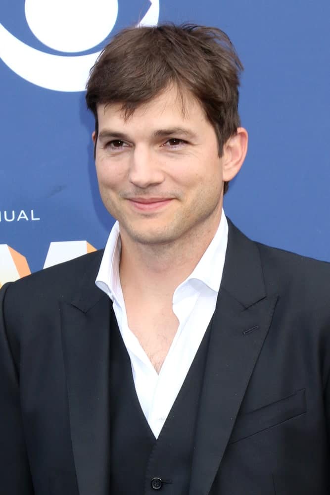 Ashton Kutcher was at the Academy of Country Music Awards 2018 at MGM Grand Garden Arena on April 15, 2018 in Las Vegas. He wore a classy three-piece suit with his short tousled side-parted fringe hairstyle and bright smile.