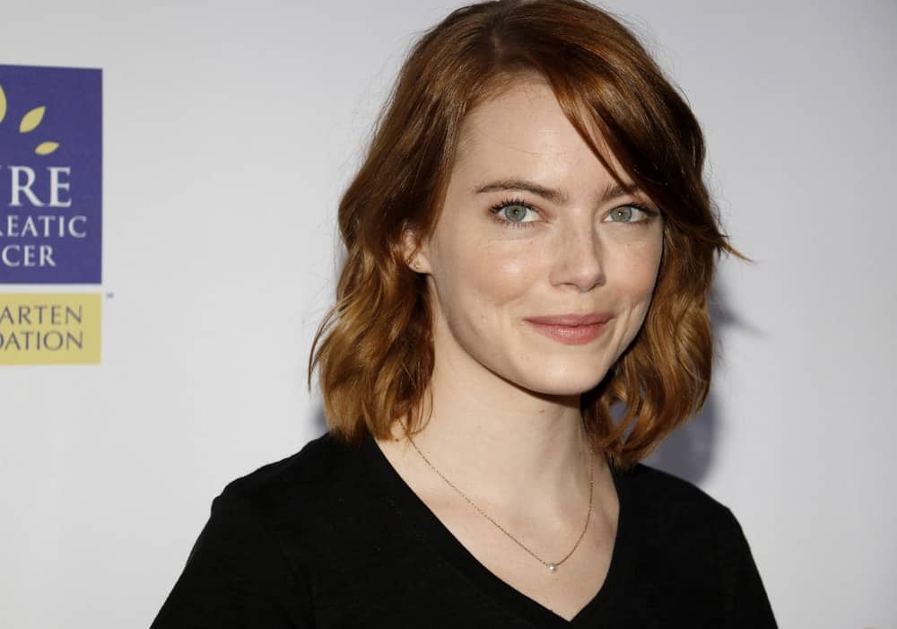 Emma Stone went with a simple black casual shirt and short wavy red hair complemented by long side-swept bangs at the 5th Biennial Stand Up To Cancer held at the Walt Disney Concert Hall in Los Angeles on September 9, 2016.