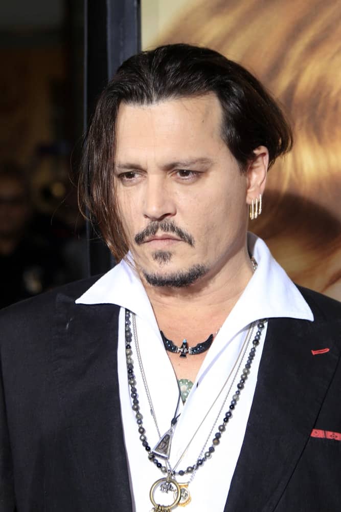 Johnny Depp was at the "The Danish Girl" Premiere at the Village Theater last November 21, 2015 in Westwood. He accessorized with multiple necklaces and earrings to complement his long side-swept hairstyle.