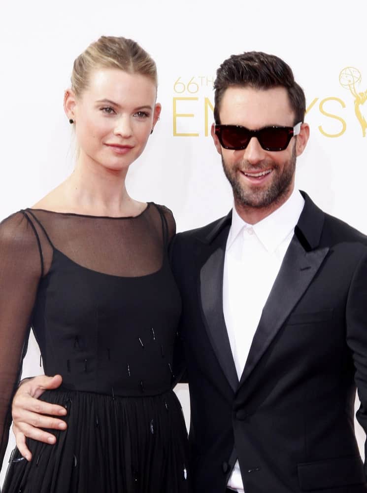 Behati Prinsloo and Adam Levine were in matching black outfits at the 66th Annual Primetime Emmy Awards in Los Angeles on August 25, 2014. Levine paired this with a slick pompadour hairstyle with slight side part.