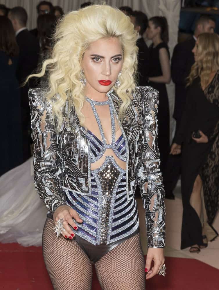 On May 2, 2016, Lady Gaga attended the Manus x Machina Fashion in an Age of Technology Costume Institute Gala at the Metropolitan Museum of Art.  She wore a shiny and silvery fashionable outfit with circuitry details and a large tousled blond hair with a slight beehive look.