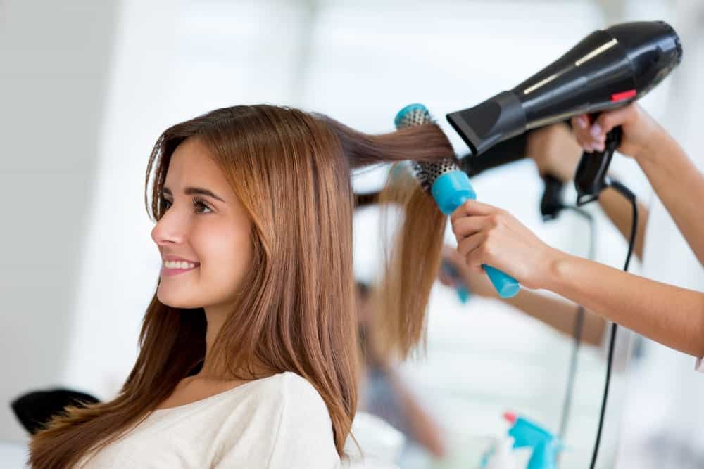 A beautiful brunette woman having her hair blow-dried.