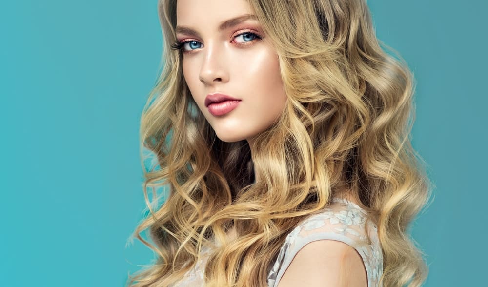 A woman with gorgeous long and loose curly hair resting on her shoulders.