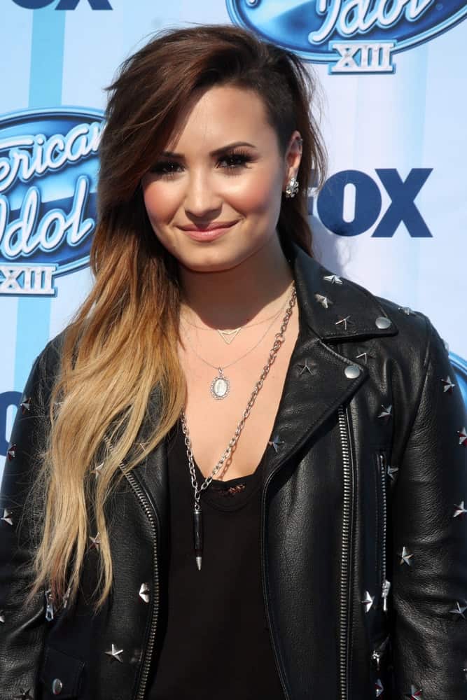 Demi Lovato wore a cool black leather jacket to complement her long side-swept highlighted tousled hairstyle with a shaved side and long side-swept bangs at the American Idol Season 13 Finale at Nokia Theater at LA Live on May 21, 2014 in Los Angeles, CA.