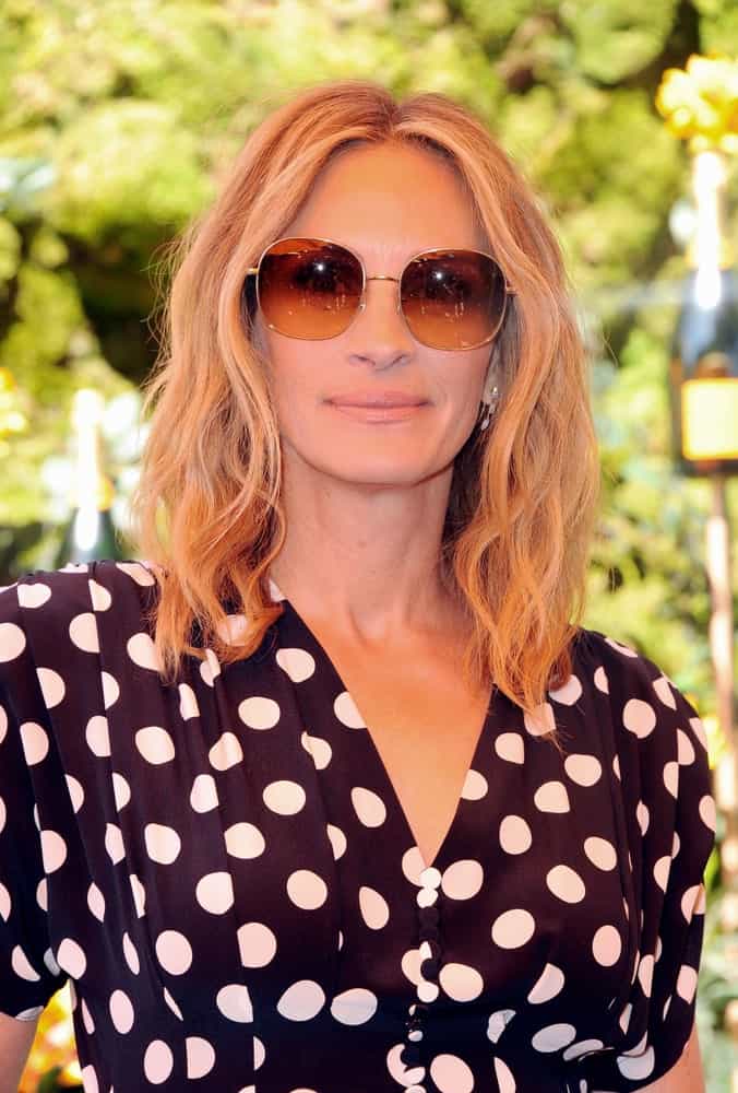 Julia Roberts wore a black dotted dress and brown shades along with center-parted blonde waves at the 10th Annual Veuve Clicquot Polo Classic held on October 5, 2019.