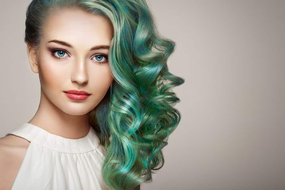 Beautiful woman with side-swept long curly dyed hair.