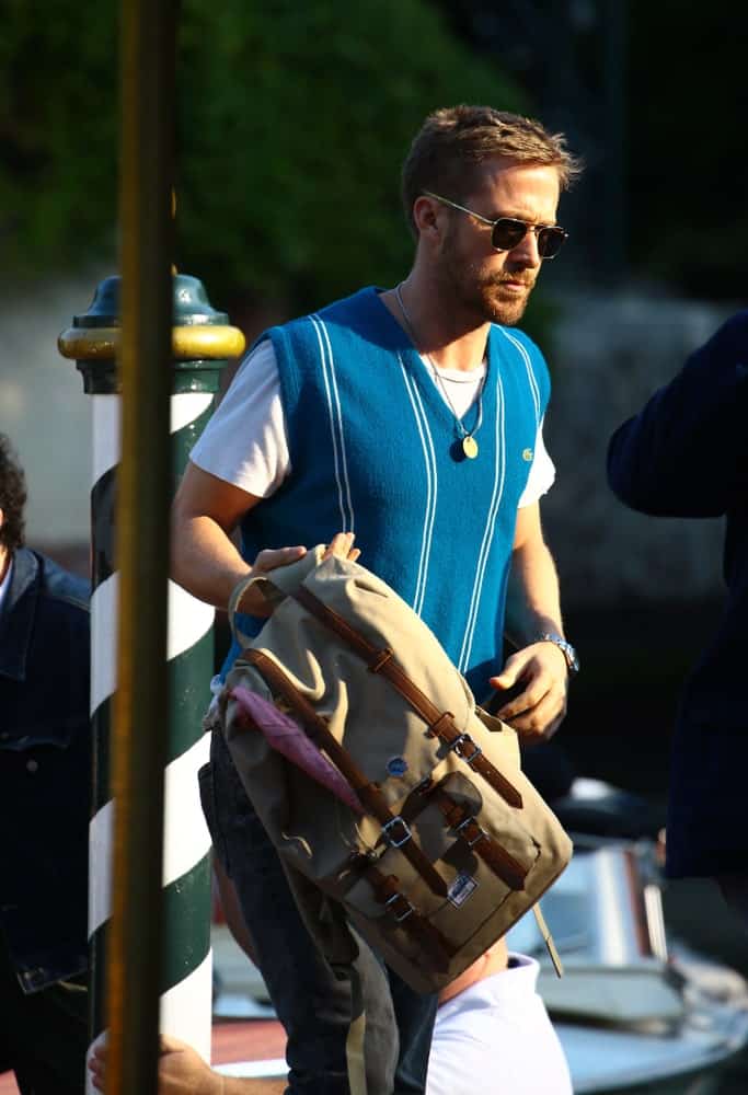 On August 29, 2018, Ryan Gosling was seen outside the Hotel Excelsior during the 75th Venice Film Festival. He wore a casual sweater vest and jeans outfit with his scruffy beard and short side-parted undercut hairstyle.