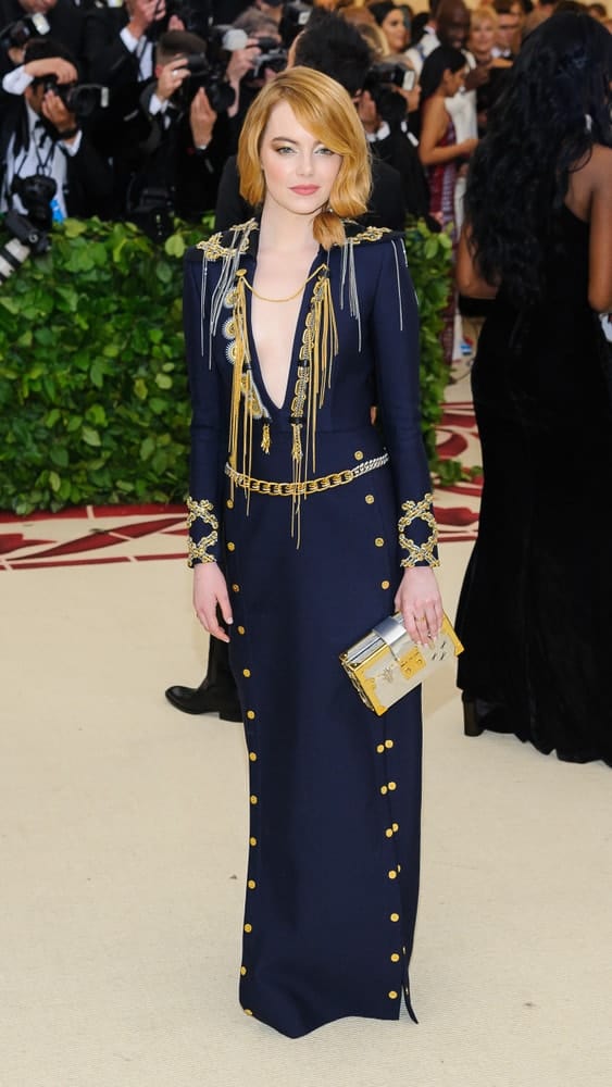 On May 7, 2018, Emma Stone opted for a sandy blond tone to her thick side-swept hairstyle with large waves during the 2018 Metropolitan Museum of Art Costume Institute Gala: "Heavenly Bodies: Fashion and the Catholic Imagination".