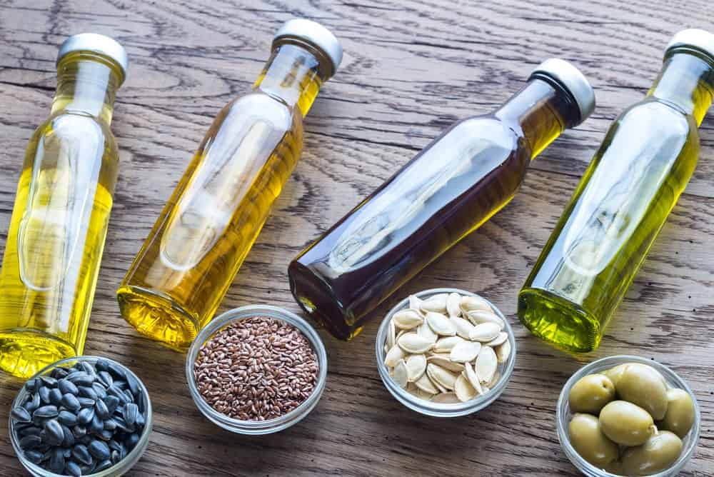 Different kinds of vegetable oils on a hardwood table.