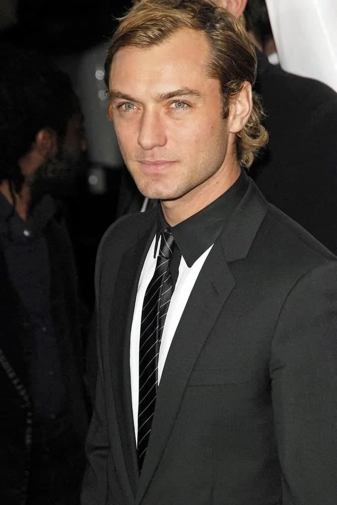 Actor Jude Law looked absolutely gorgeous with his medium-length side-parted hairstyle with some curls flipping at the tips of his hair when he attended the New York premiere of "The Holiday" in 2006.