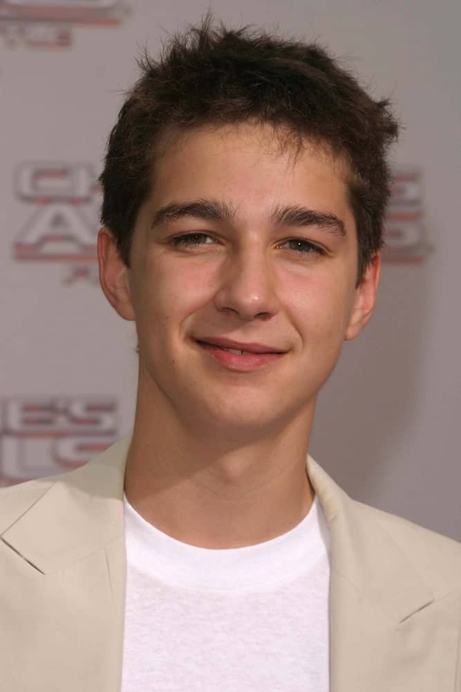 Shia LaBeouf arrived at the premiere of 'Charlie's Angels: Full Throttle' on June 18, 2003 in Los Angeles, California wearing a simple light gray suit and white shirt and a simple and short hairstyle that has a slightly messy look.