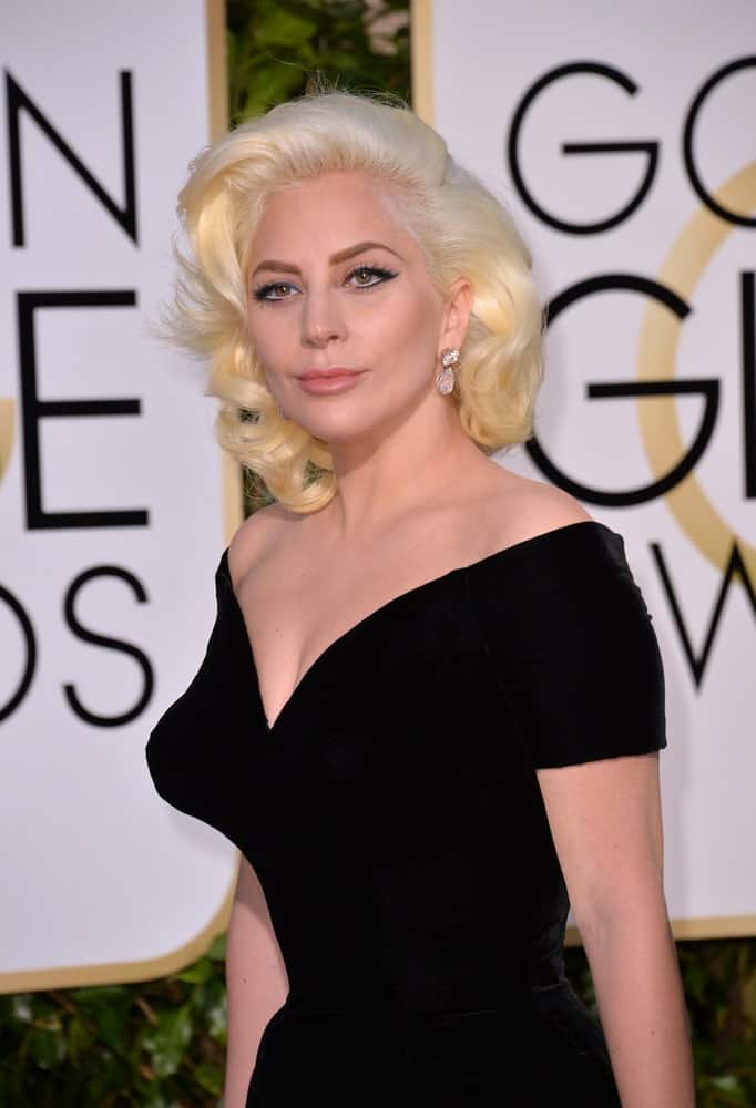 On January 10, 2016, Lady Gaga attended the 73rd Annual Golden Globe Awards at the Beverly Hilton Hotel. She wore a classy vintage black dress that complemented her white blond side-swept curls with subtle highlights.