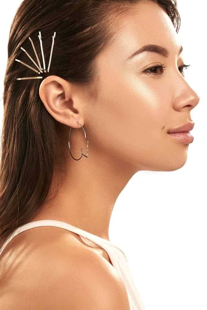 Side profile of a beautiful woman wearing bobby pins.