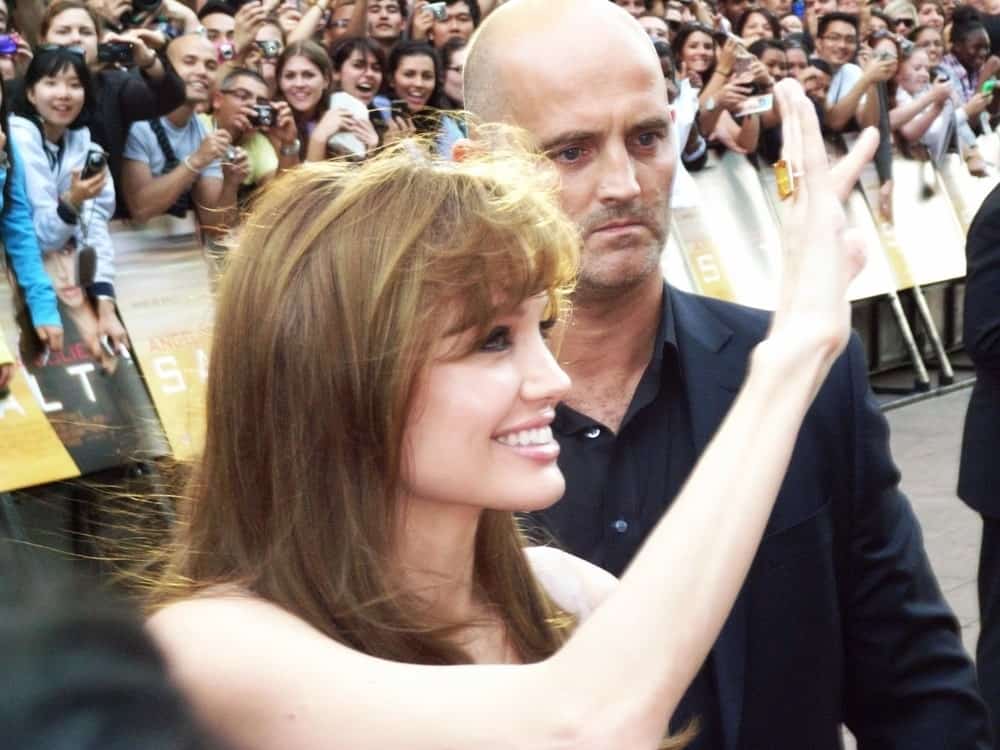 Angelina Jolie greeted her many fans with a brilliant smile and a wave at the Salt Premiere August 16th, 2010 in Leicester Square London, England. She wore her hair loose and tousled in a brown hue with bangs.