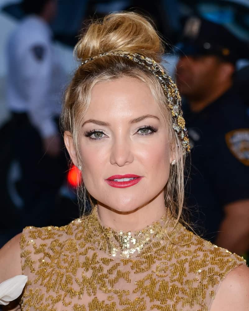 On May 04, 2015, Kate Hudson attended the 'China: Through The Looking Glass' Costume Institute Gala held at the Metropolitan Museum of Art in New York City, New York. She wore a gold sequined sheer dress with her messy top knot bun hairstyle with loose tendrils.