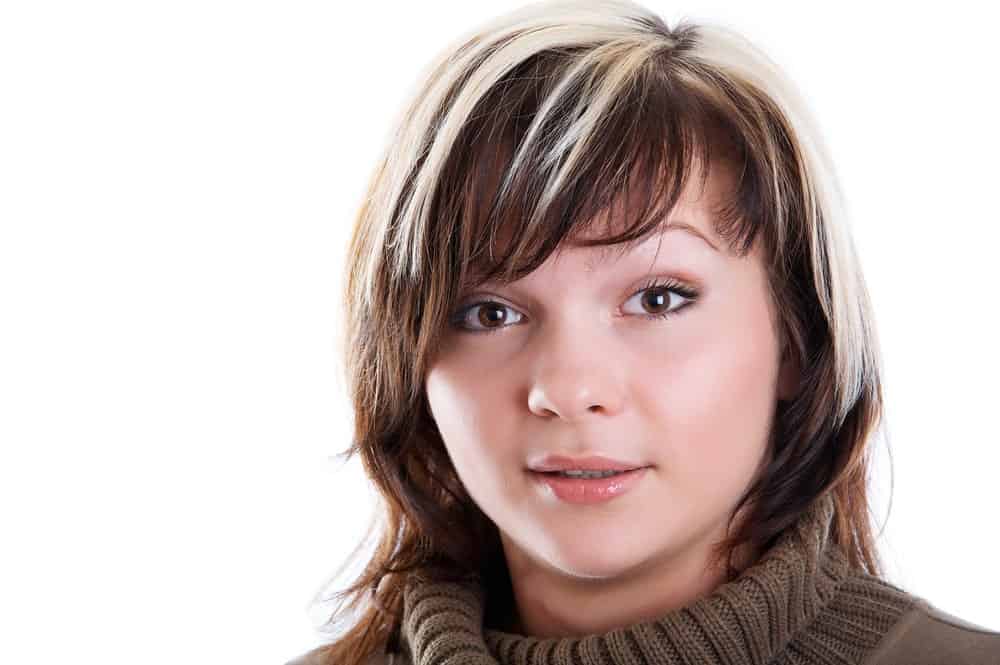 A woman with a round face sporting short highlighted hair.