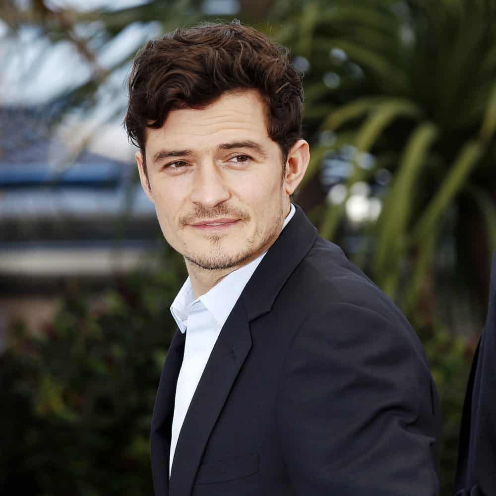 Actor Orlando Bloom attended the 'Zulu' Photo-call during the 66th Cannes Film Festival on May 26, 2013 in Cannes, France. His lovely curls were side-parted and slightly highlighted.