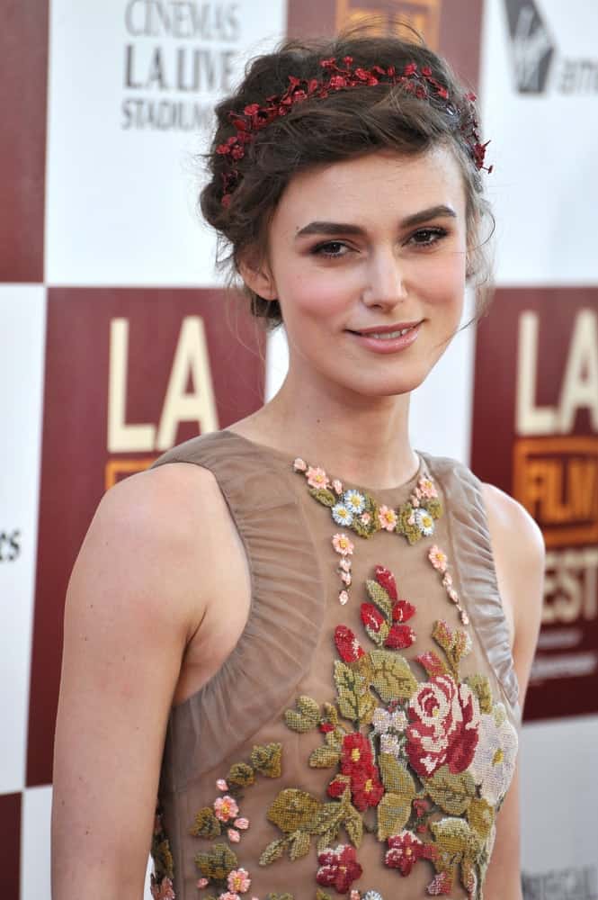 Keira Knightley was at the world premiere of her movie "Seeking a Friend for the End of the World" at the Regal Cinemas LA Live on June 19, 2012 in Los Angeles, CA. Her floral dress paired well with her loose and messy braided hairstyle with a bun, a hairband and loose tendrils on the sides.