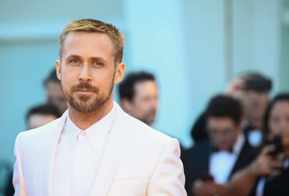 Ryan Gosling walked the red carpet of the 'First Man' screening during the 75th Venice Film Festival on August 29, 2018 in Venice, Italy. He wore an all-white suit with his short sandy blond hair in a side-parted crew cut fade hairstyle.