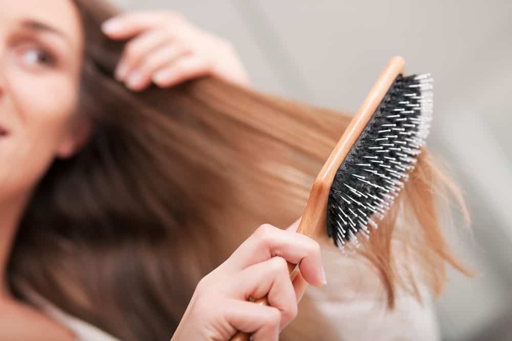 A close look at a woman brushing her hair.