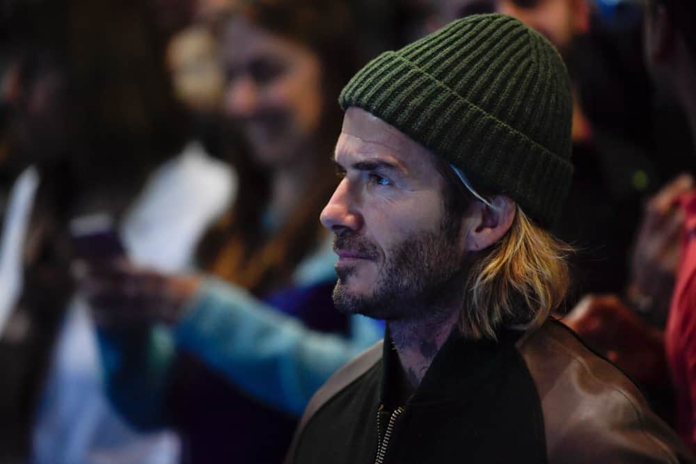 David Beckham paired his long blonde hair with a green beanie as he enjoys the final game between Grigor Dimitrov & David Goffin at Nitto ATP Finals World Tour on November 19, 2017.