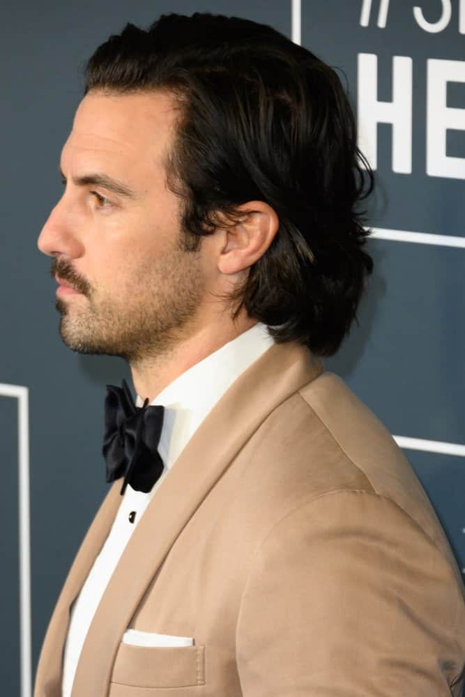 Milo Ventimiglia appeared with a neat wavy style showing off his black hair and beard during the 25th Annual Critics' Choice Awards at Barker Hangar on January 12, 2020.