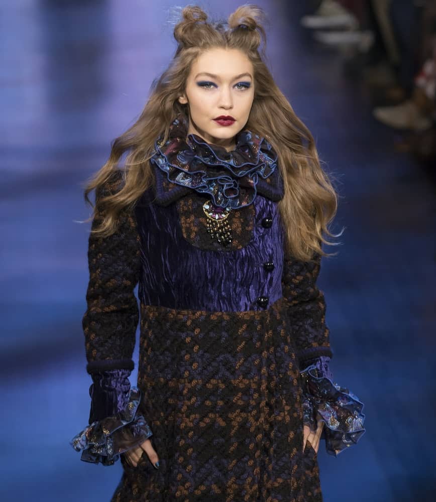 Gigi Hadid walked the runway at the Anna Sui Fall Winter 2017 fashion show during New York Fashion Week on February 15, 2017. She wore a detailed dress to go with her half up hairstyle that has two small buns to imitate cat ears.