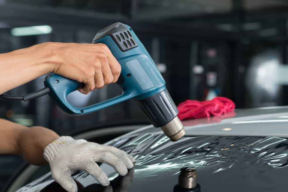 Heat Gun Vs Hair Dryer. A heat gun being used to apply car window tint.