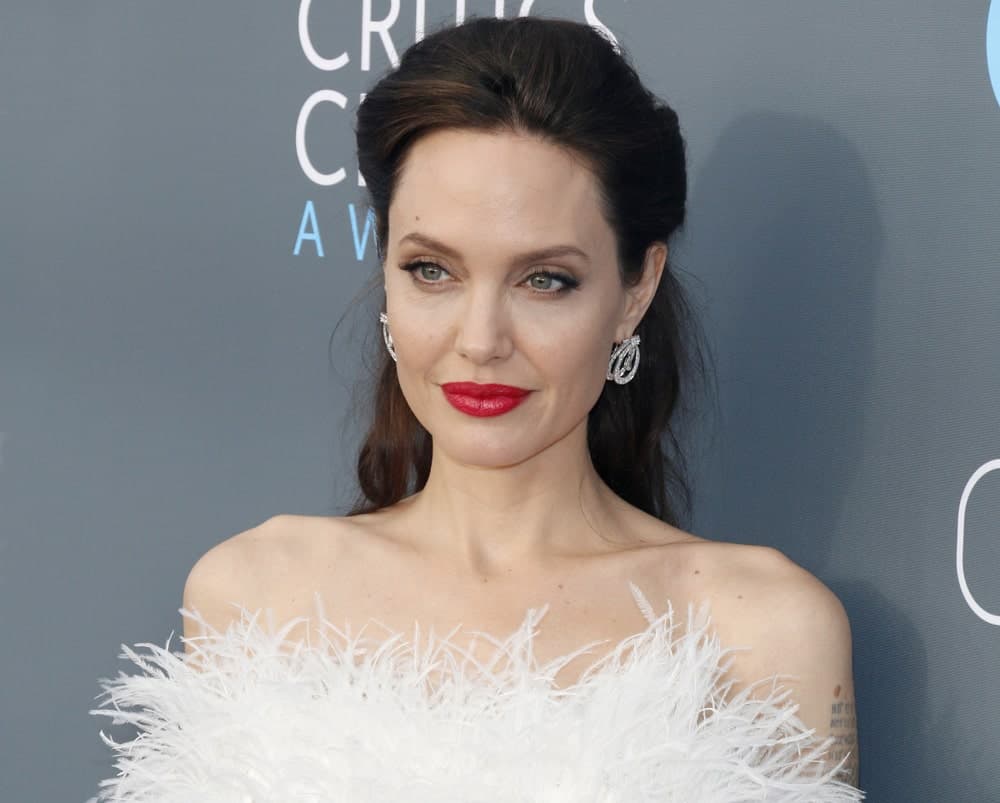 Angelina Jolie wore a stunning white strapless dress with feathers to pair with her lovely half up hairstyle at the 23rd Annual Critics' Choice Awards held at the Barker Hangar in Santa Monica, USA on January 11, 2018.