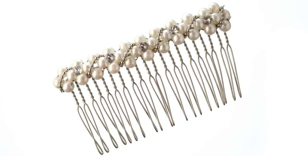 A close look at a side hair comb adorned with pearls.