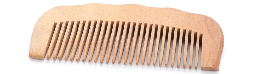 A close look at a wide-toothed wooden comb.