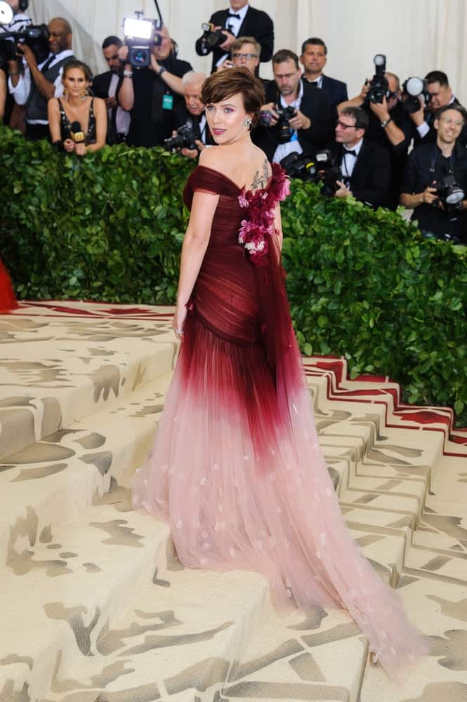 Scarlett Johansson looked like a goddess in her two-toned long dress with floral decors and her highlighted side-swept wavy short hair with a slight tousle at the 2018 Metropolitan Museum of Art Costume Institute Benefit Gala on May 7, 2018 in New York.