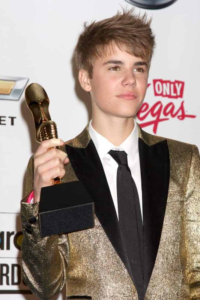 Justin Bieber appeared with a tousled, spiked 'do at the 2011 Billboard Music Awards at MGM Grand Garden Arena. Stunning and shimmering gold tuxedo completed the sleek look.