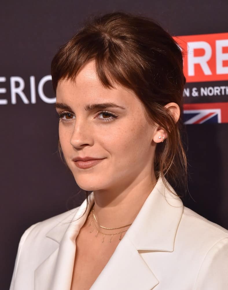 Emma Watson attended the BAFTA Tea Los Angeles on January 06, 2018 in Beverly Hills, CA. SHe was quite classy in her white smart casual outfit to pair with her messy bun upstyle with short bangs and tendrils.