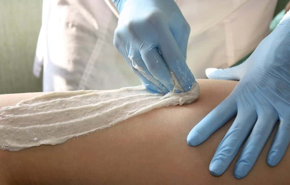 Sugar waxing a woman's body.