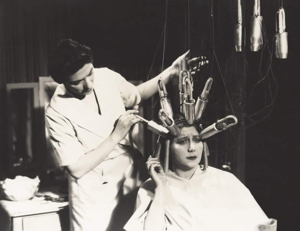 An old black and white image of a 1920s permanent waving machine.