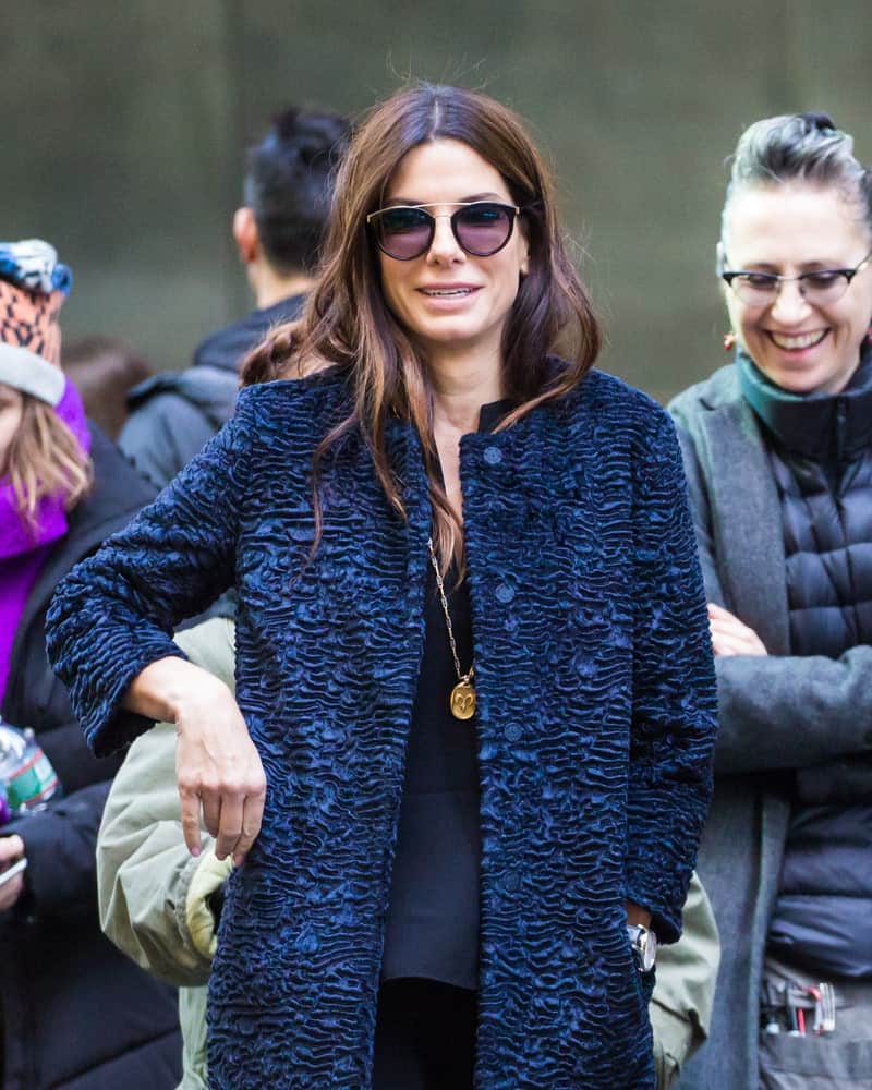 Sandra Bullock was seen on set of 'Ocean's 8' last October 28, 2016 in New York City. She wore a casual outfit that went great with her tousled and loose wavy hairstyle that has highlights.