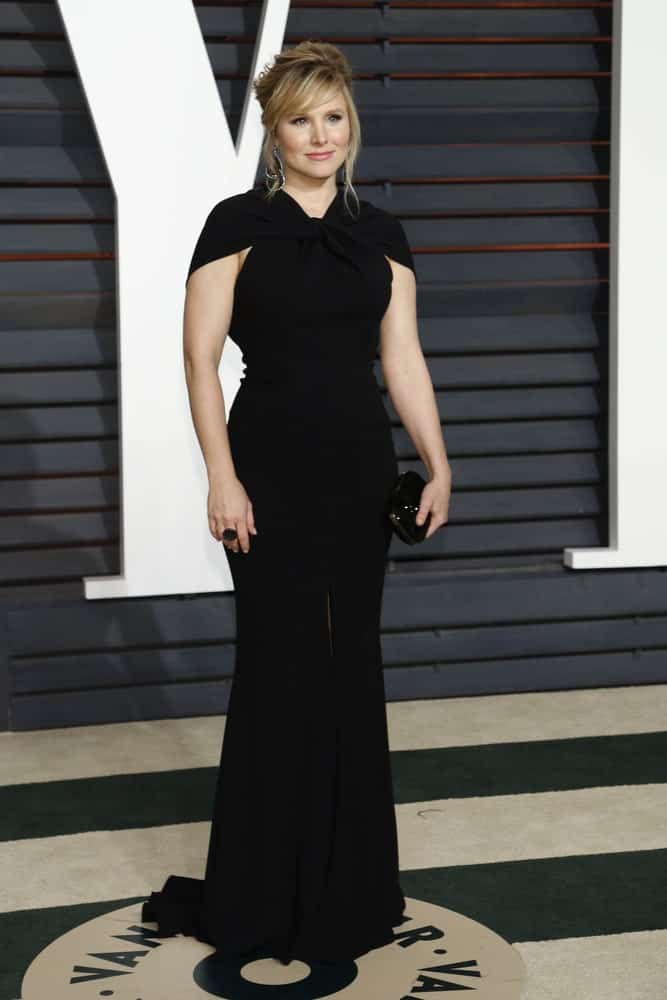 Kristen Bell arrived at the Vanity Fair Oscar Party 2015 at the Wallis Annenberg Center for the Performing Arts on February 22, 2015, wearing a classic black dress along with a fab upstyle that's incorporated with side-swept bangs and tendrils.