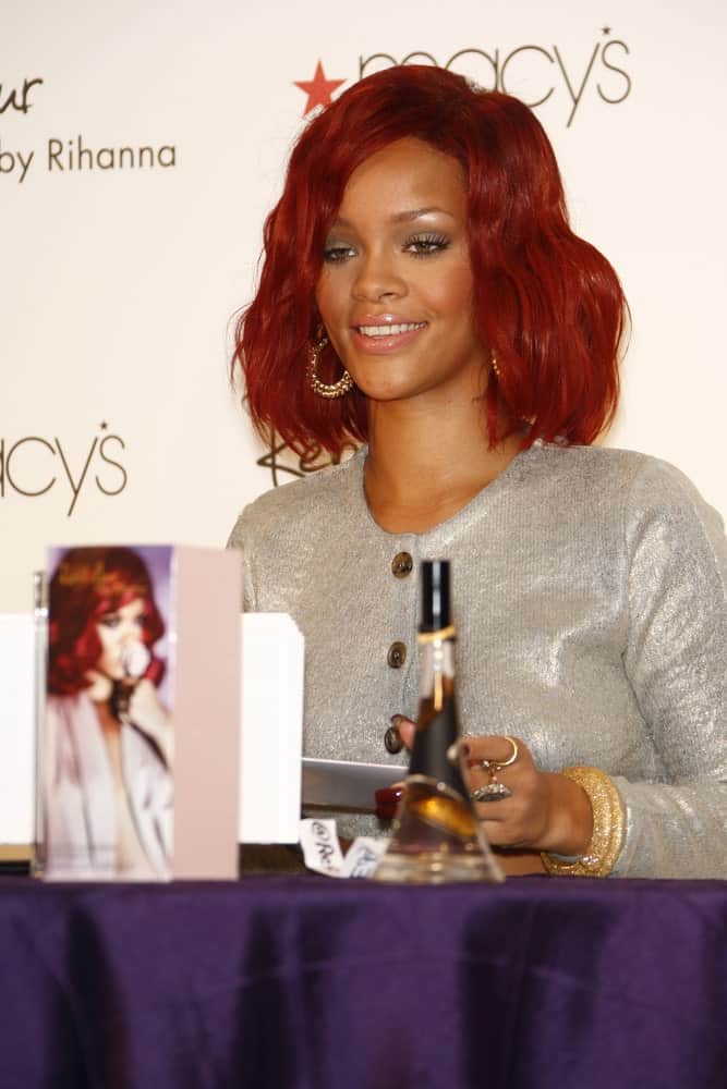 Rihanna was at Macy's in Lakewood, California at the launch of her first fragrance 'Reb'l Fleur' on February 18, 2011. She was lovely in her gray outfit and shoulder-length red hairstyle with waves and tousles.