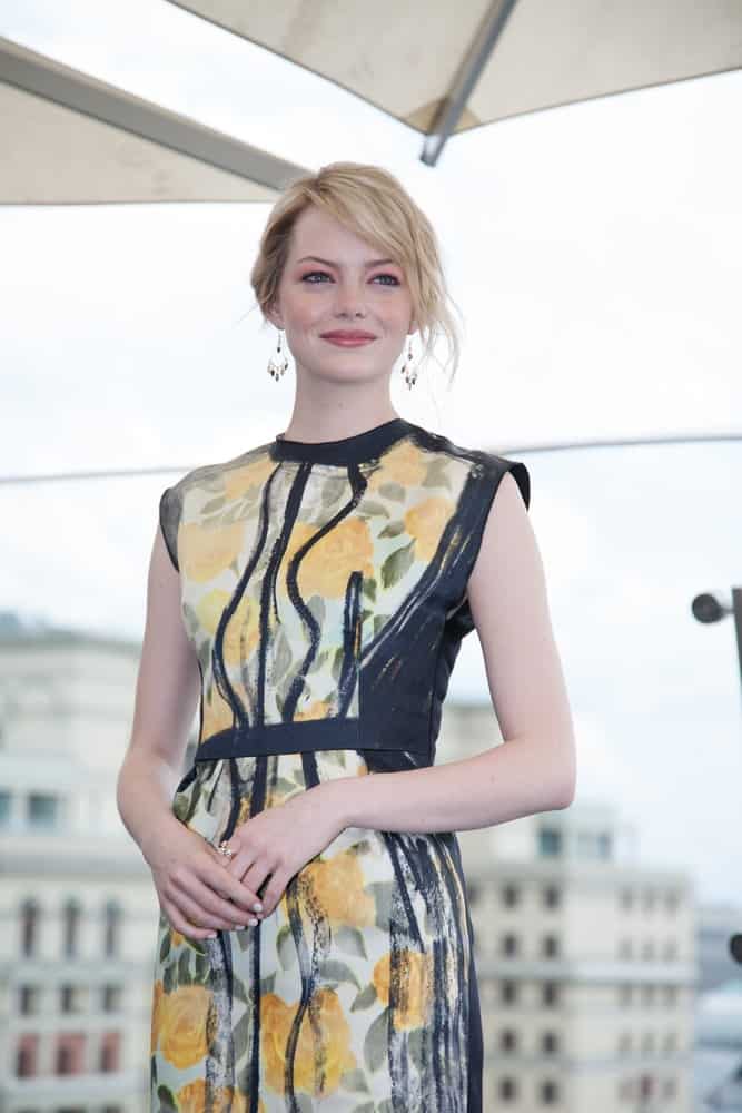 Actress Emma Stone was at the premiere of the movie "The Amazing Spider-Man" on June 15, 2012 at the RITZ HOTEL in Moscow, Russia. She wore a lovely and colorful floral dress that totally went great with her messy and loose bun hairstyle with bangs.