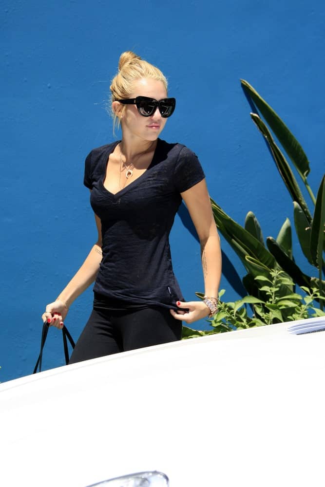 Miley Cyrus was seen at a Pilates studio on July 16, 2012 in West Hollywood, California. She was wearing her yoga pants with her sandy blond hairstyle swept up to a high bun hairstyle with highlights.