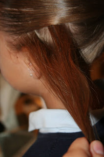 Side view of young girl's hair being styled into "Hair Headband" hairstyle