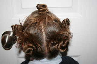 Back view of young girl modeling "Holiday Twisty Buns" hairstyle