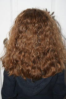 Back view of Young girl' modeling 2nd Day Curls from Double-French Braids