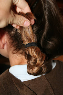 Back view of young girl's hair being styled into "Double-French Braids w/Messy Flips"