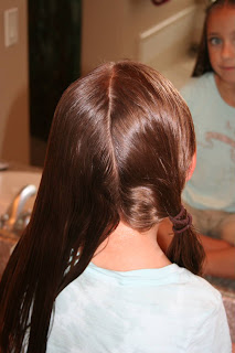 Back view of girl's hair being styled in "Criss-Cross French Braids"